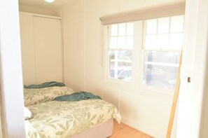 A bedroom with a bed, a window, and a door. - Mallee Drift - Exhale and Relax (James Well)