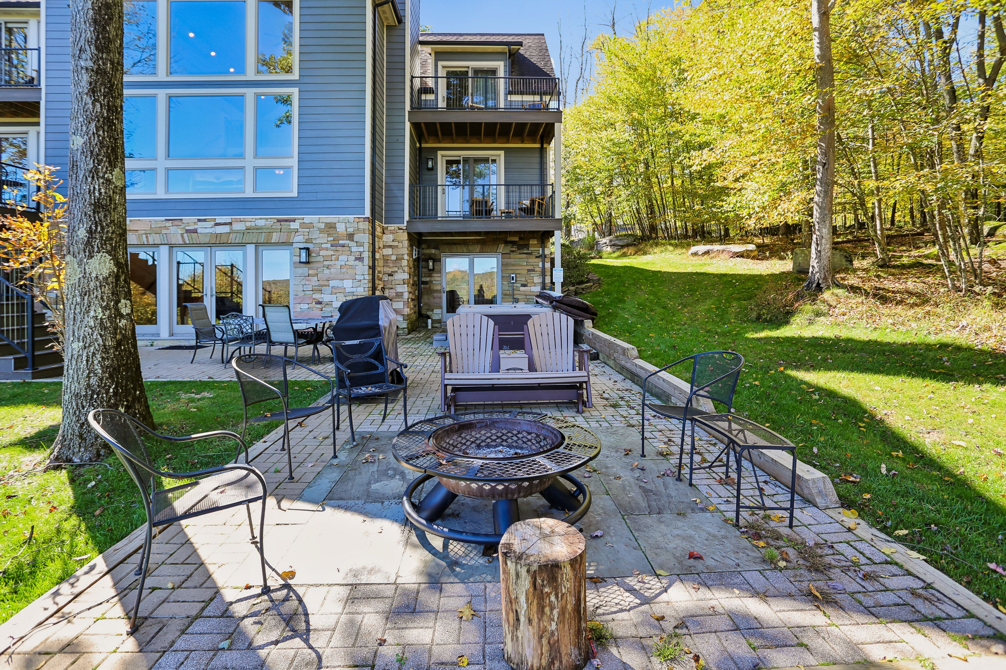 A patio with outdoor seating, a fire pit, and a stone wall.