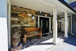 A stone facade with a wooden bench and a welcome sign. - Mountaintop retreat with 5 bedrooms, hot tub, pool table, and community pool! (McHenry)