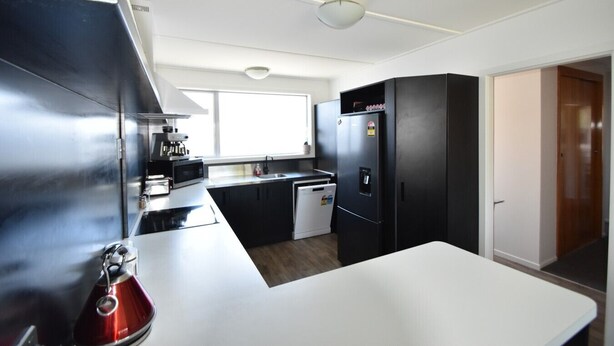 A compact kitchen with a microwave, stove, refrigerator, and dishwasher.