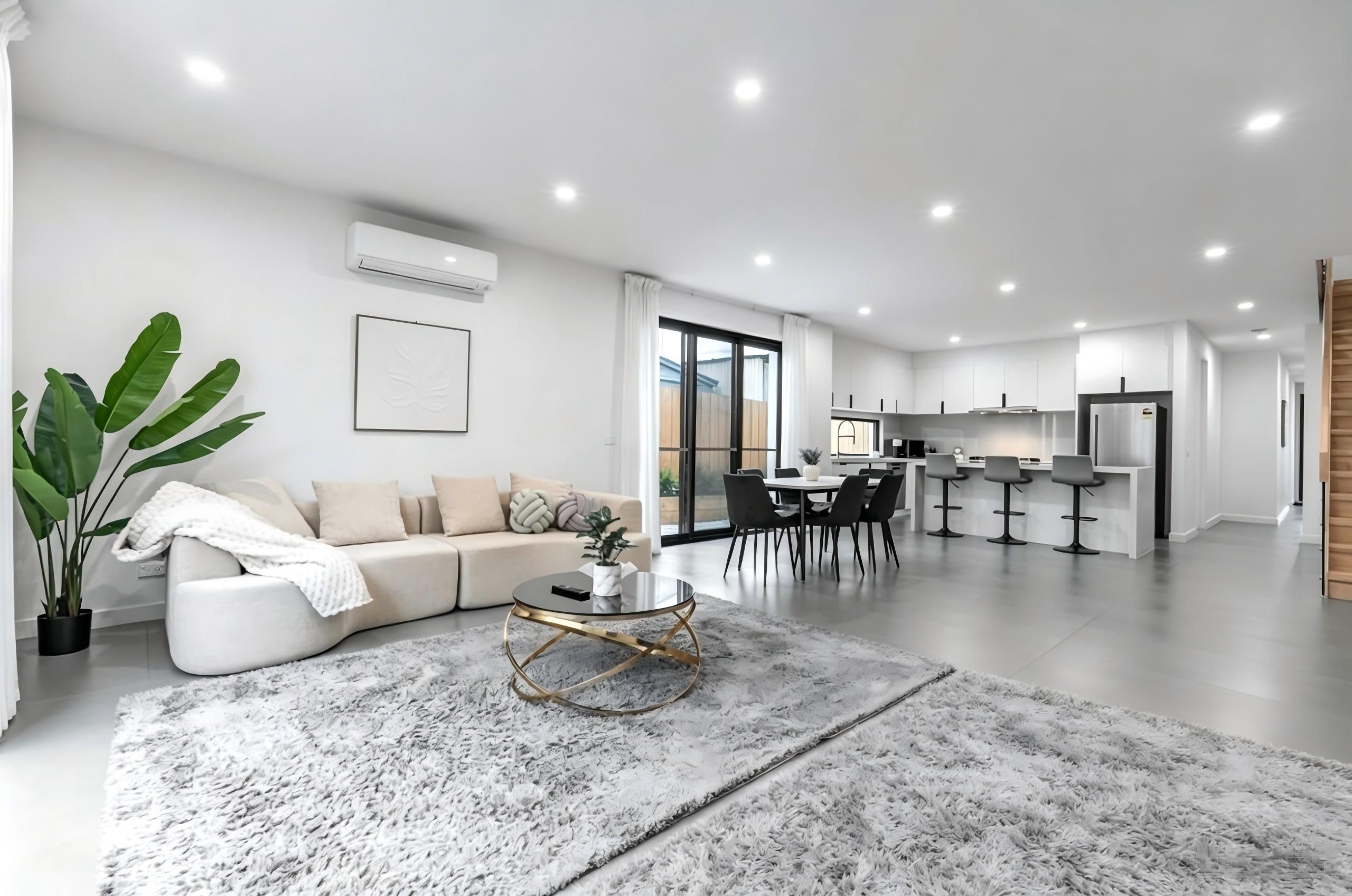 A modern living room with a sofa, coffee table, and a large plant.