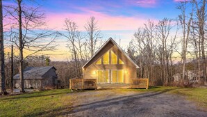 A wooden cabin with a porch, large windows, and a gravel driveway. - 🏡 Modern Mountain Lodge | ♨️ Hot Tub • 🎮 Game Room • 🏖️ Big Bass Lake • 🐶 Pet Friendly (Gouldsboro)