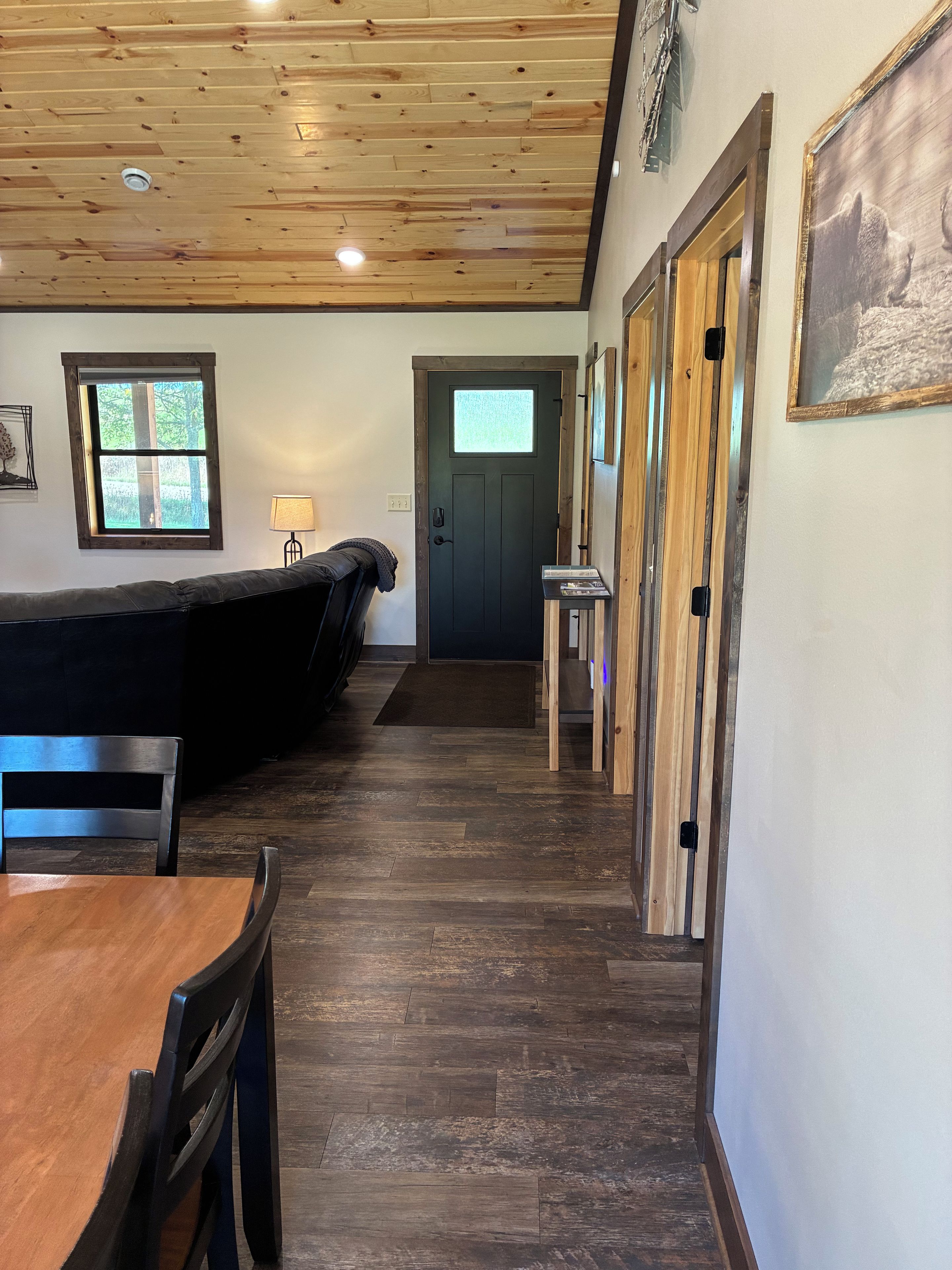 Une pièce avec un plafond en bois, une porte dotée d’une fenêtre, une table et des chaises.