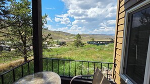 A balcony with a view of a rural landscape, including houses and a road. - New Listing! True ski-in/out newly remodeled all-four seasons mountainside condo (Granby)