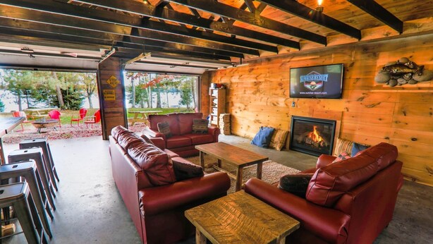 Ein gemütlicher Innenbereich mit Ledersofas, einem Holztisch und einem Kamin.