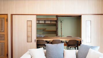 Una habitación con sofá, una mesa de comedor con sillas y un mueble con cajones.