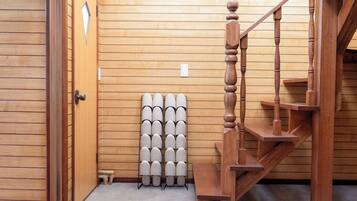 A wooden staircase with a handrail, a wall-mounted light switch, and a radiator.