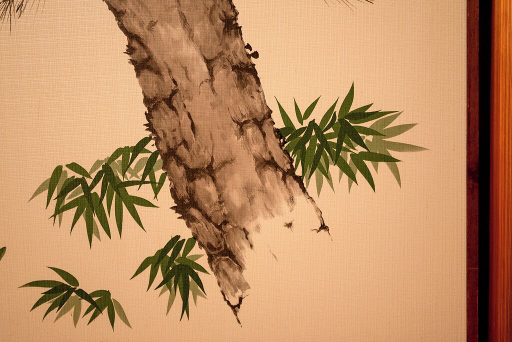 A close-up of a tree trunk with green leaves.