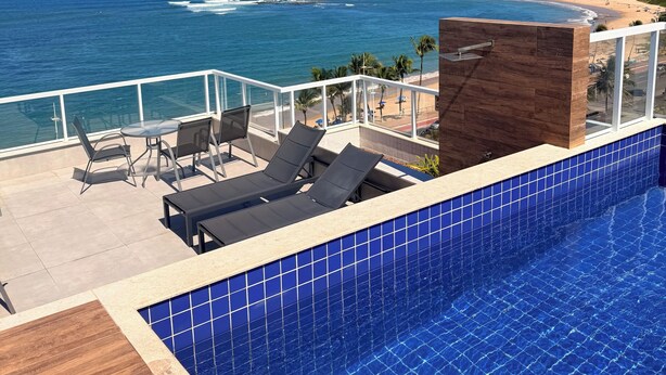 A rooftop pool with a view of the ocean and beach. - Beachfront Studio in Piatã | Incredible View, Wi-Fi, Smart TV and Garage (Salvador)