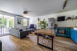 Una cocina moderna con comedor, ventanas amplias y vista a la vegetación.