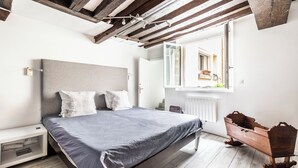 A bedroom with a bed, bedside table, and a wooden chest of drawers. - LUXURY LOFT IN THE HEART OF PARIS (Paris)