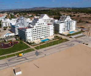 Ein mehrstöckiges Hotel mit Schwimmbad in Strandnähe.