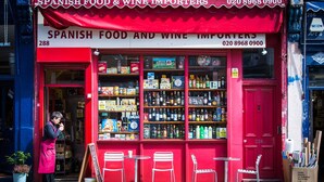 Una vetrina con un tendaggio rosso, scaffali pieni di prodotti assortiti e un'insegna che indica l'attività come importatore di prodotti alimentari e vino spagnoli.