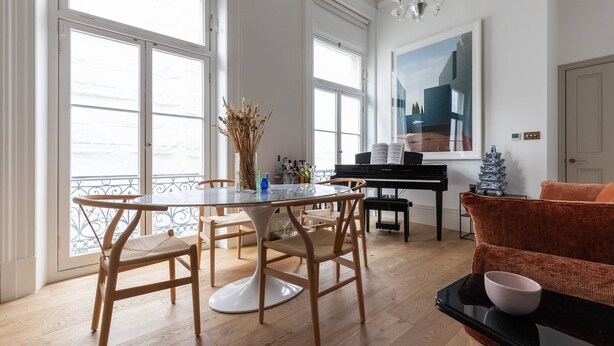 A spacious room with a dining table, chairs, a piano, and a sofa. - Spring Gardens - One Bedroom Apartment, Sleeps 2 (London)