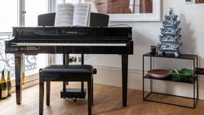 A piano, a framed artwork, a decorative vase, and a small table with a bowl and a plant. - Spring Gardens - One Bedroom Apartment, Sleeps 2 (London)