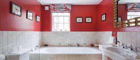 A bathroom with a white toilet, a bathtub, and a sink.