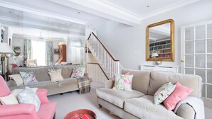 Een woonkamer met een bank, fauteuil en een boekenkast.