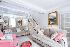 Ein Wohnzimmer mit einer Couch, einem Sessel und einem Bücherregal.
