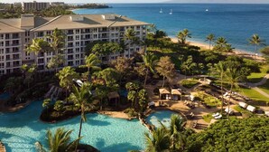 Ein Resort mit Pool, Palmen und Blick auf den Ozean.