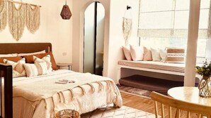 Un dormitorio con una cama, una silla de madera, un ventilador de techo y una ventana con persianas.