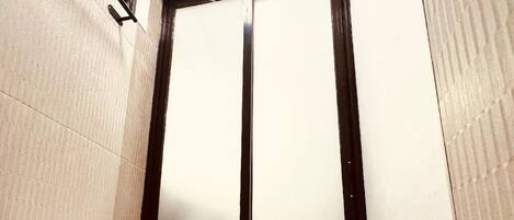 Un baño con inodoro, toallero y puerta.
