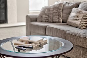 A round glass coffee table with books and a remote control. - Peaceful 3 bedroom home in Tyler (Tyler)