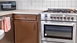 A kitchen with a built-in microwave, a stainless steel stove with a digital display, and a brown cabinet with a drawer. - Peaceful 3 bedroom home in Tyler (Tyler)