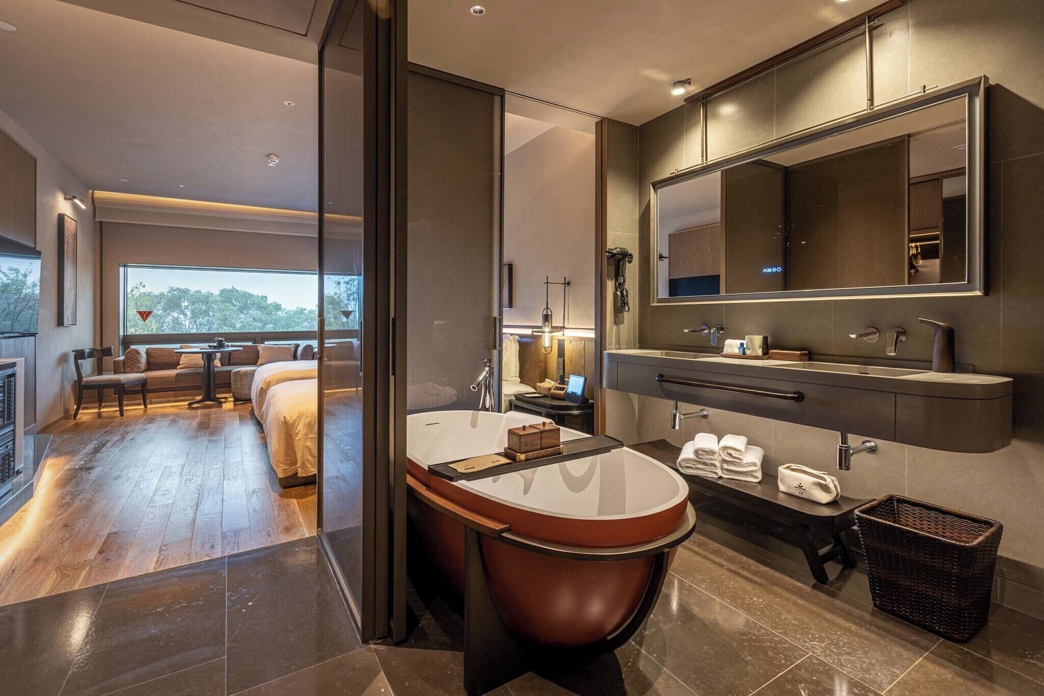 Une salle de bain moderne avec une baignoire sur pieds, un grand miroir et un meuble-lavabo doté d’un plan de travail.