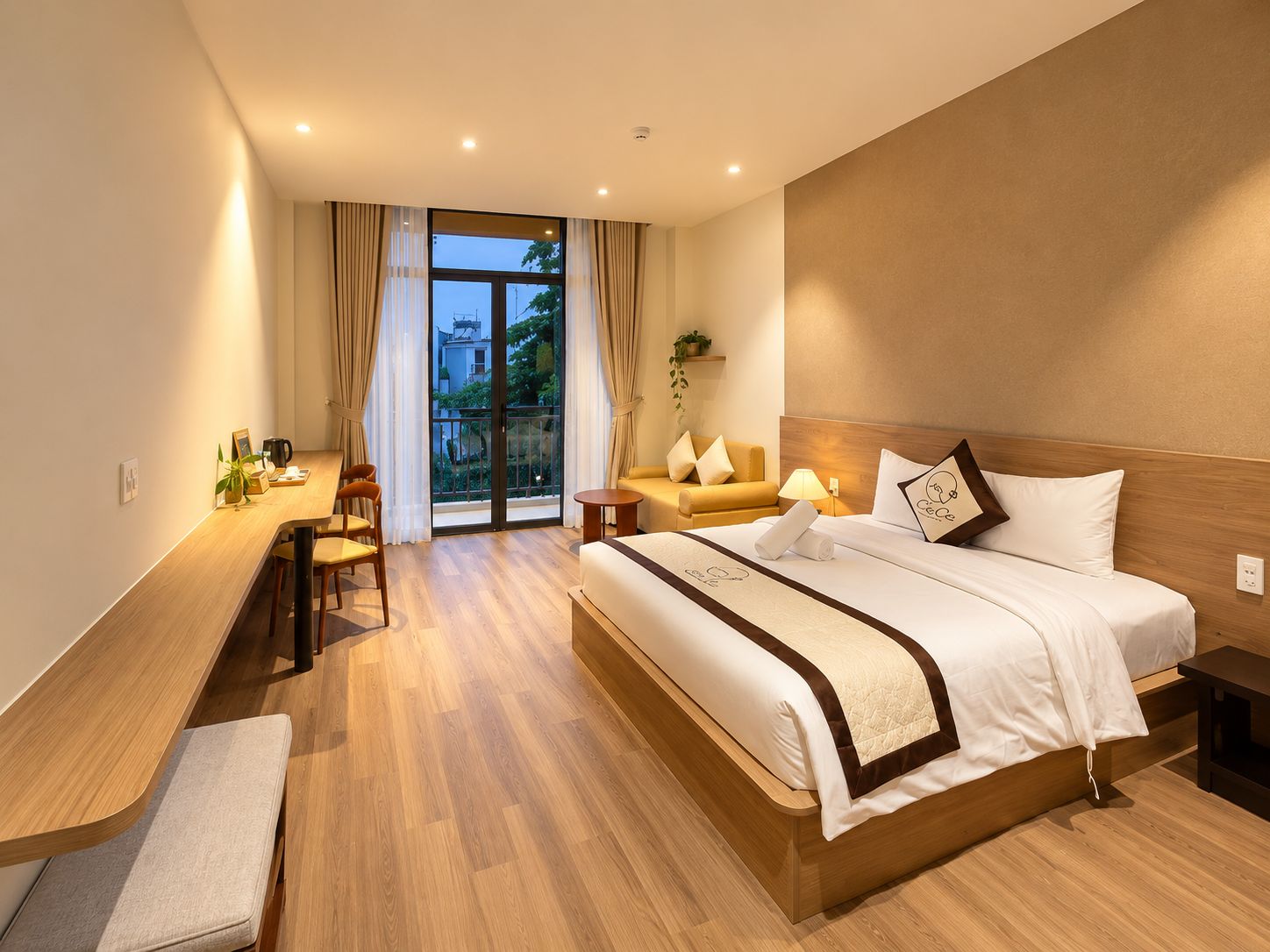 Een hotelkamer met een bed, een bank, een bureau en een houten zitbank.