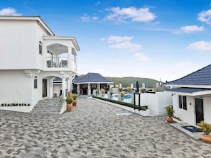 A hotel courtyard with a patterned tile floor, a pool area, and a covered seating area. - Beyond The Sea 2 (Montego Bay)