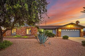 A two-story house with a brick facade, a garage, and a well-maintained garden. - Heated Private Pool at no extra charge, Arcade & BBQ, Prime N. Phoenix Location! (Phoenix)
