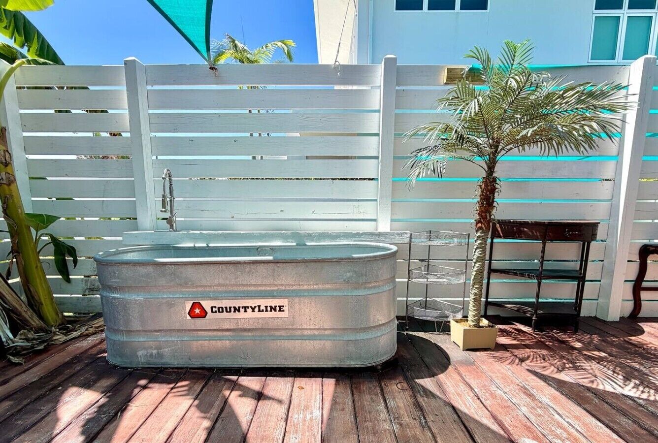 Un bain à remous en métal, portant l’étiquette « COUNTYLINE », installé sur une terrasse en bois.