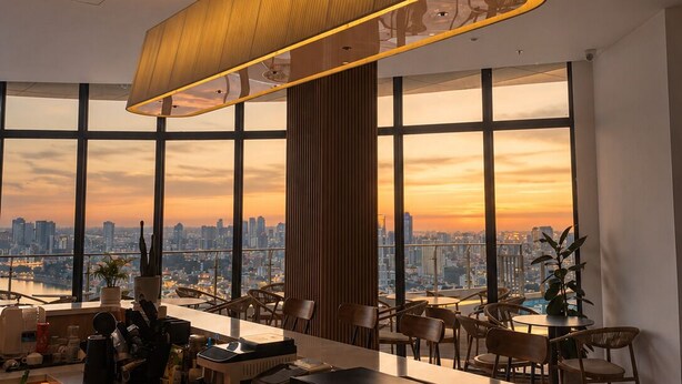 A modern bar area with a city view, a large hanging lamp, and a bar counter with various items. - Wealth Mansion (Phnom Penh)