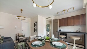 Ein modernes Wohnzimmer mit Essbereich, Küche und einer Treppe.