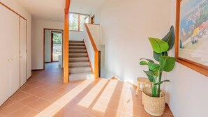 Ein geräumiger Flur mit Treppe, einem Blumentopf und einem gerahmten Bild an der Wand.