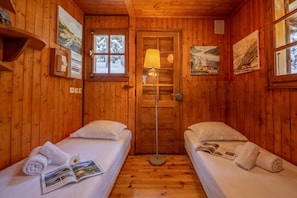 A cabin with two beds, a wooden floor, a door, and a window. - Chalet Petit Poucet 2BR Retreat in forest, Le Tour (Argentière), France (Le Tour (Argentière))