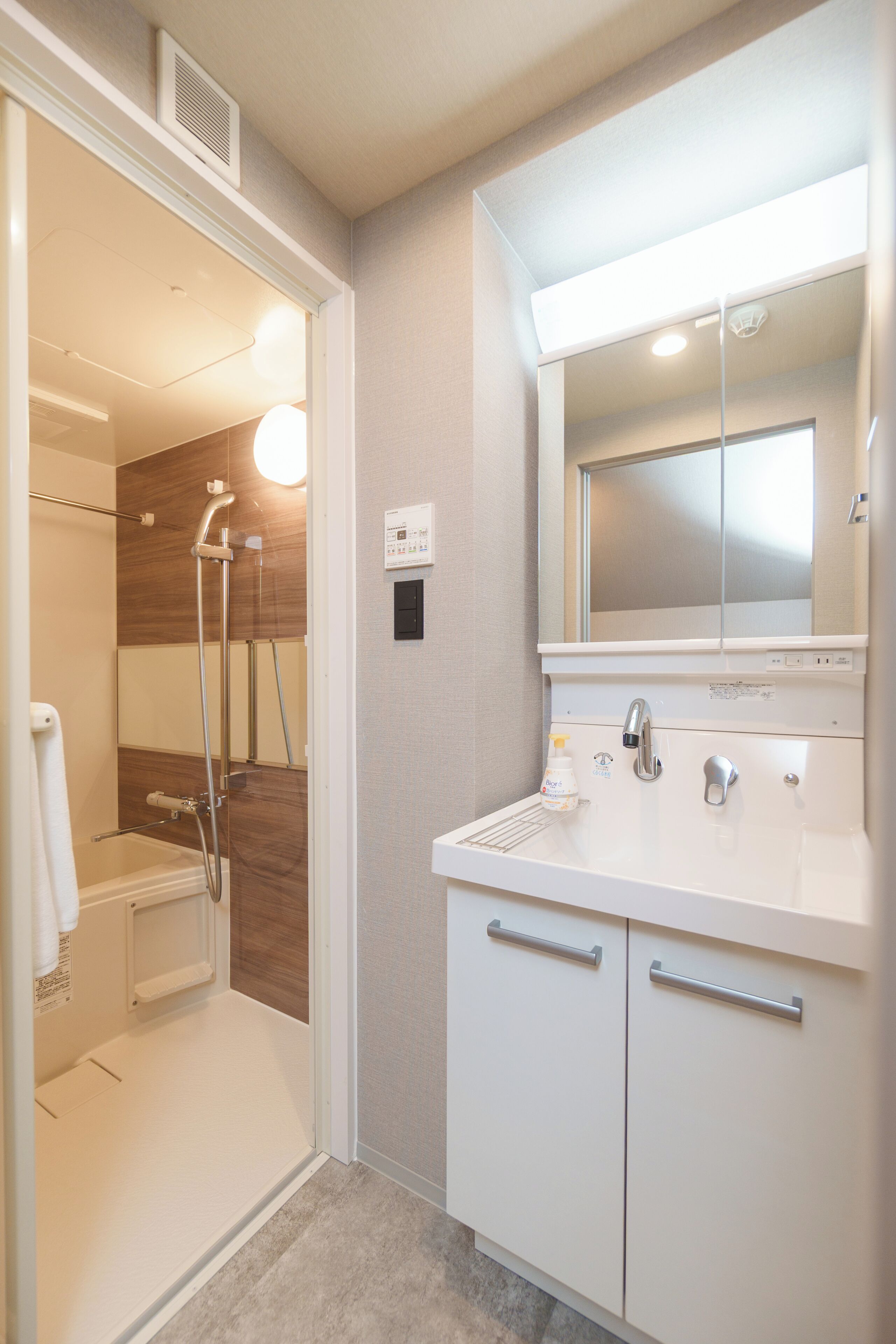 A bathroom with a shower, a sink, and a mirror.