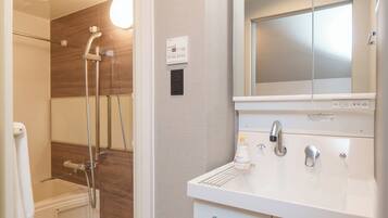 A bathroom with a shower, a sink, and a mirror.