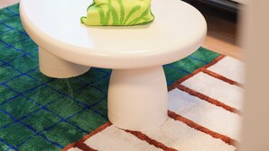 A white round table with a green cloth in a room with a white sofa and a patterned rug. - Tora Hotel Nishikamata (Ota City)