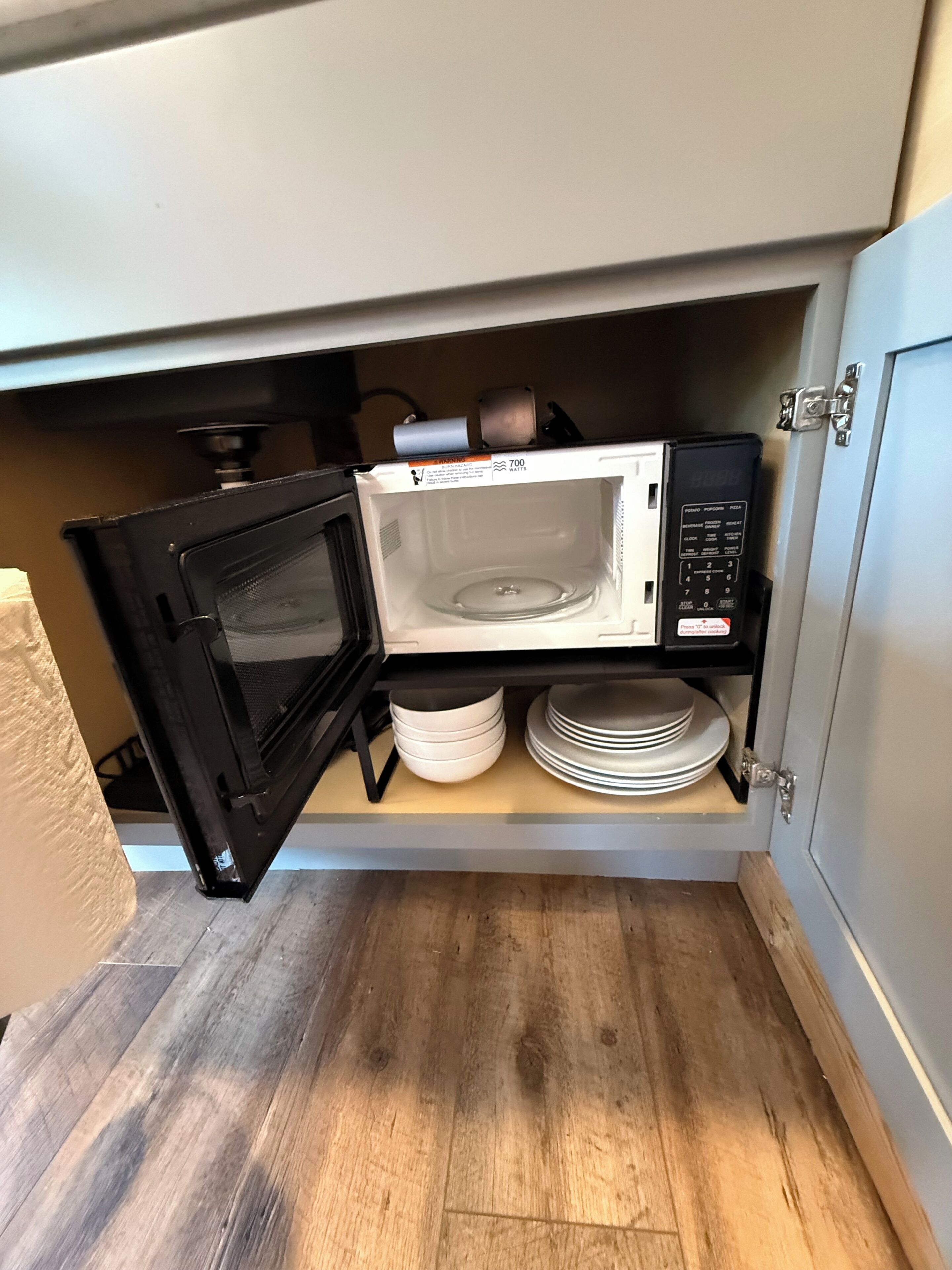 A kitchen with a microwave and a stove, both in a cabinet.