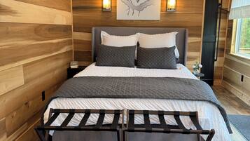 A wooden-paneled room with a bed, a wall-mounted sign, and a window.