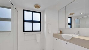 A modern bathroom with a large window, a white sink, and a mirror. - 1 Jade Court - Centrally Located, Brand New Furnishings (Maroochydore)