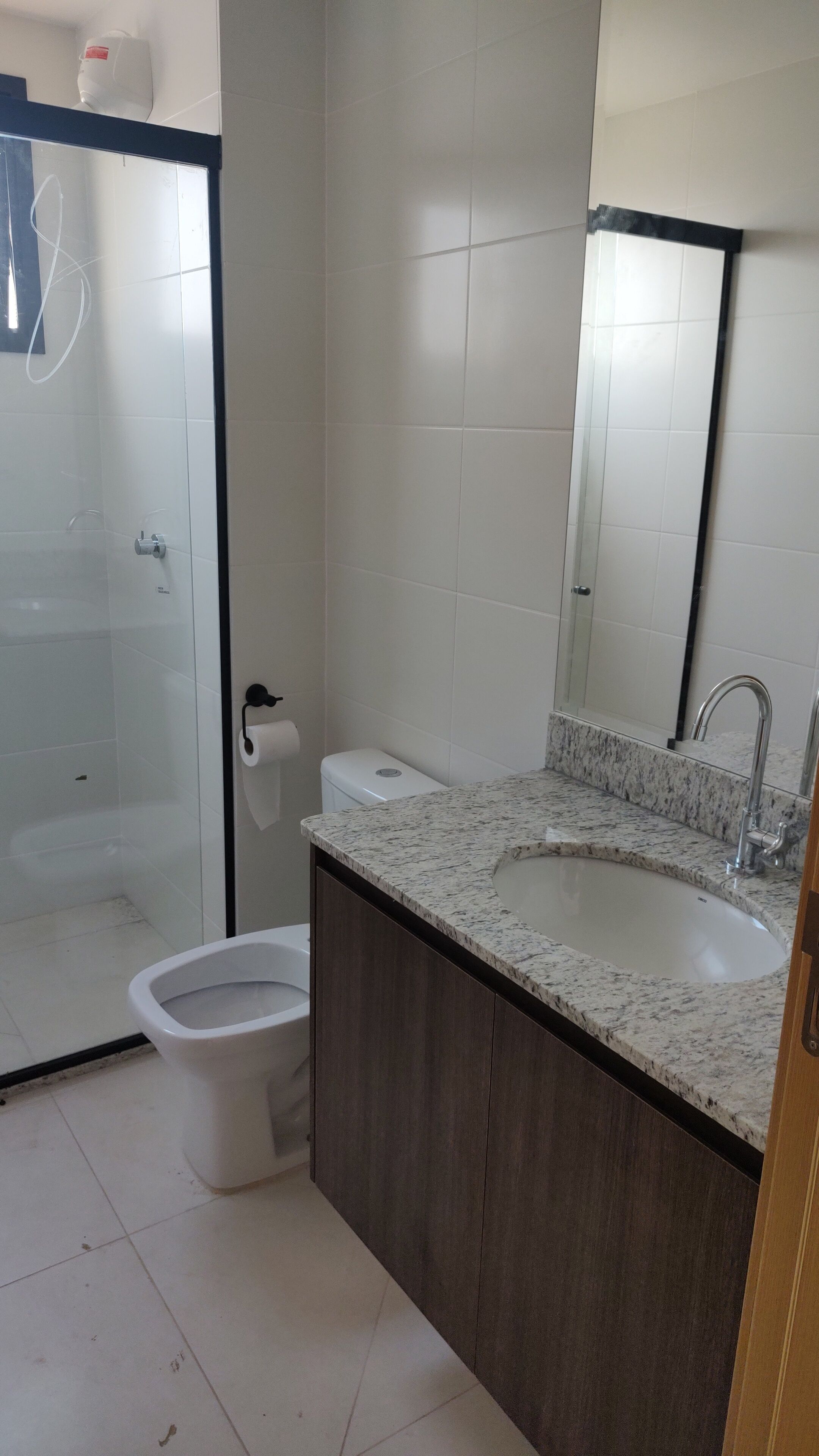 A bathroom with a shower, toilet, sink, and a mirror.