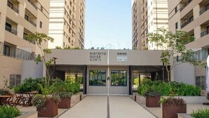 A modern building entrance with a sign reading 'DISTRITO GOIAS NORTE 3930.' - 2-bedroom apartment, close to the 44th Street area, bus station, airport, and Flamboyant Shopping Mall. (Goiânia)