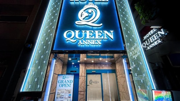 The exterior of Hotel Queen Annex with a prominent illuminated sign, a grand opening announcement, and a marble entrance. - Hotel QUEEN ANNEX (Tokyo)