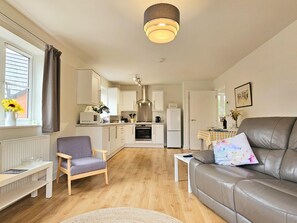 A modern kitchen with white cabinets, a built-in oven, and a refrigerator. - Charming Home Near Ludlow Town Centre - Pass the Keys (Ludlow)