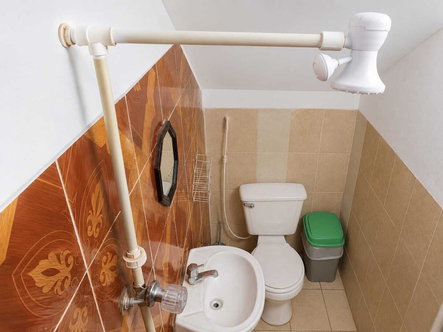 Casa de banho com sanita, bidé, lavatório e espelho.