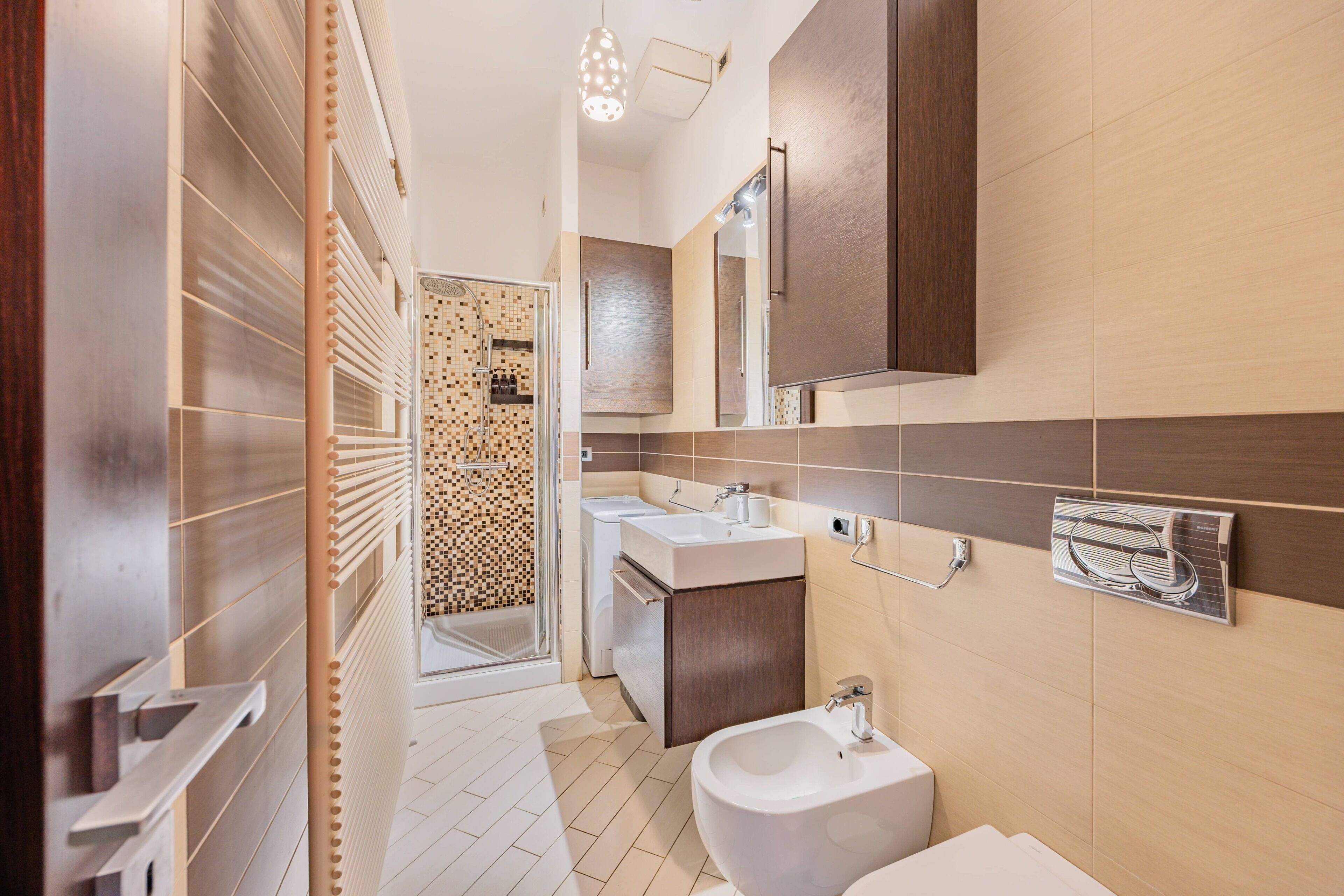 Ein modernes Badezimmer mit Dusche, Waschbecken und Bidet, mit Fliesenboden und Holzelementen.