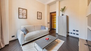 Ein modernes Wohnzimmer mit einer Couch, einem Couchtisch mit Äpfeln und abstrakter Wandkunst.