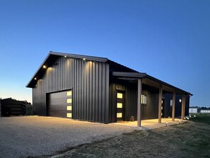 Un bâtiment moderne doté d’un grand portail de garage, d’un espace porche abrité et d’une entrée bien éclairée.